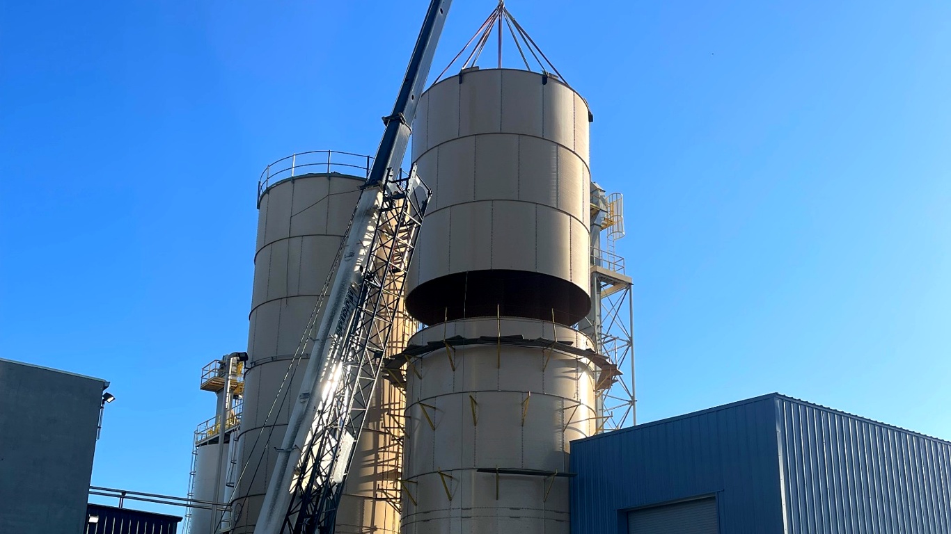 Steel storage tank installation with crane lift in progress by Thompson Tank