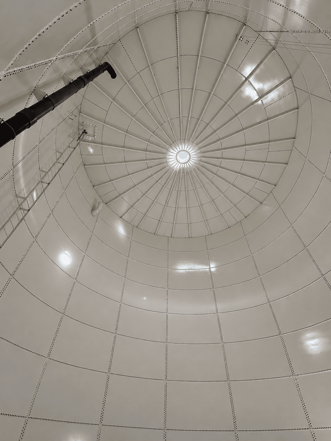 Interior view of bolted steel water storage tank showing roof structure and access ladder
